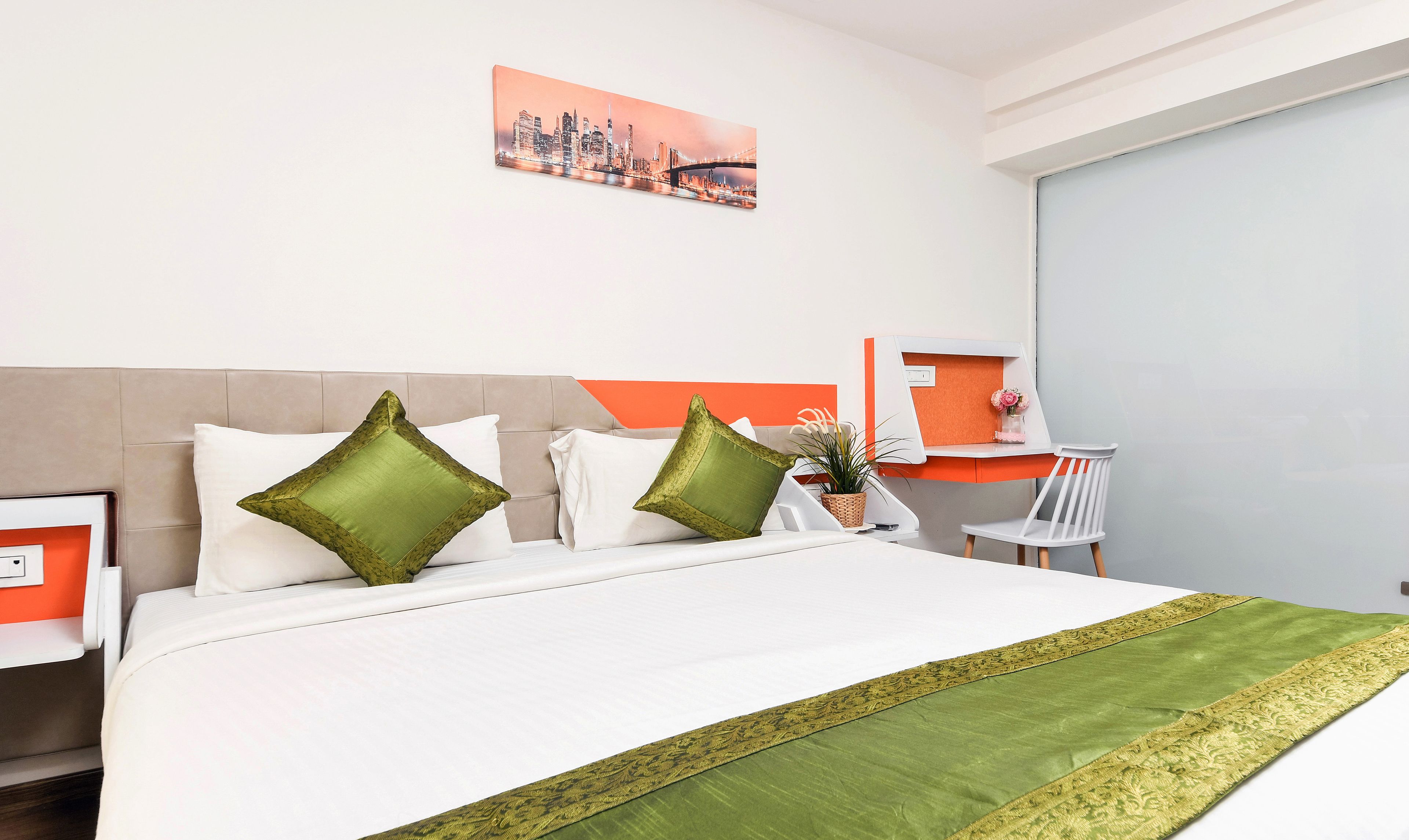 A hotel room with a bed, a desk, and a chair.