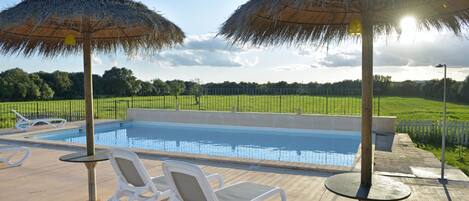 Piscine extérieure, parasols de plage, chaises longues