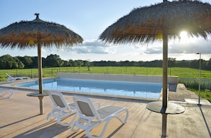 Utomhuspool, parasoller och solstolar