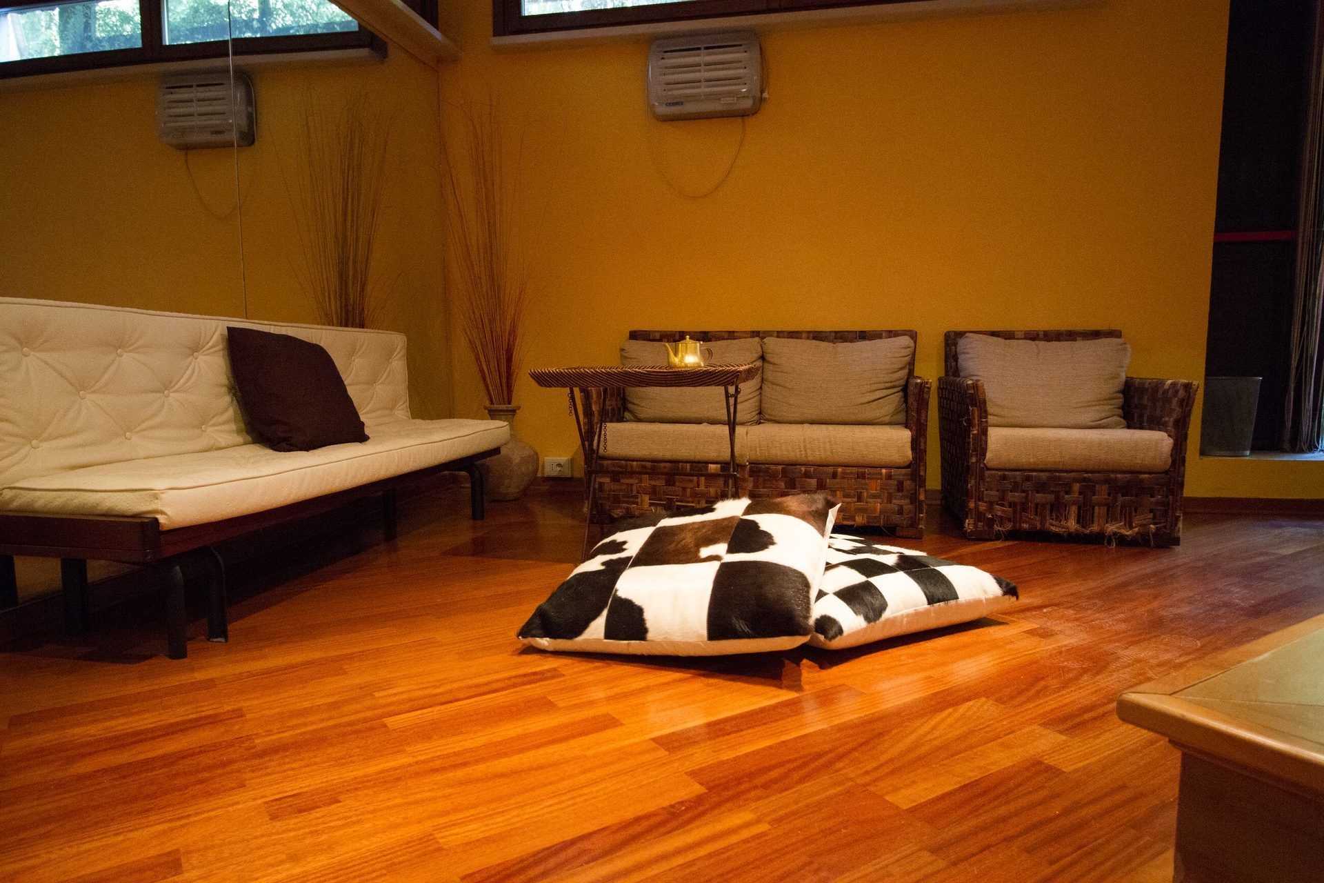 A living room with a sofa, two armchairs, a coffee table, and a patterned rug.