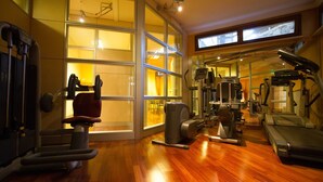 A gym with exercise equipment, wooden flooring, and large windows. - Hotel Corona (Pescasseroli)