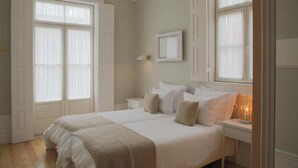 Un dormitorio con una cama grande, dos mesitas de noche y una lámpara de pared.