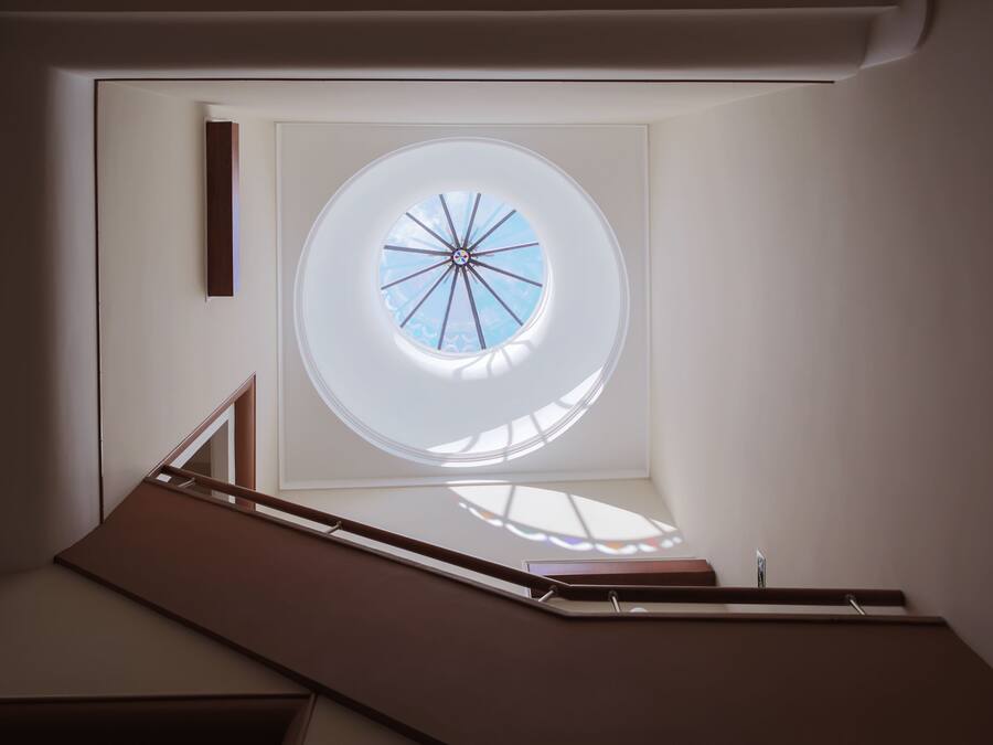 A modern interior with a skylight, a staircase, and a minimalist design.