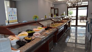 Montaje de bufé con diferentes alimentos y un letrero.