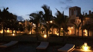 A resort with outdoor seating and palm trees, featuring a building with a tower. - Life Resort St.Thomas Royal Palm (Watamu)