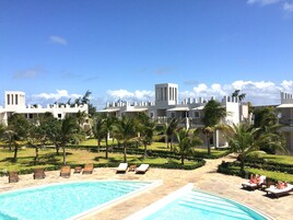 A resort with a pool area, lounge chairs, and a view of the resort's buildings.