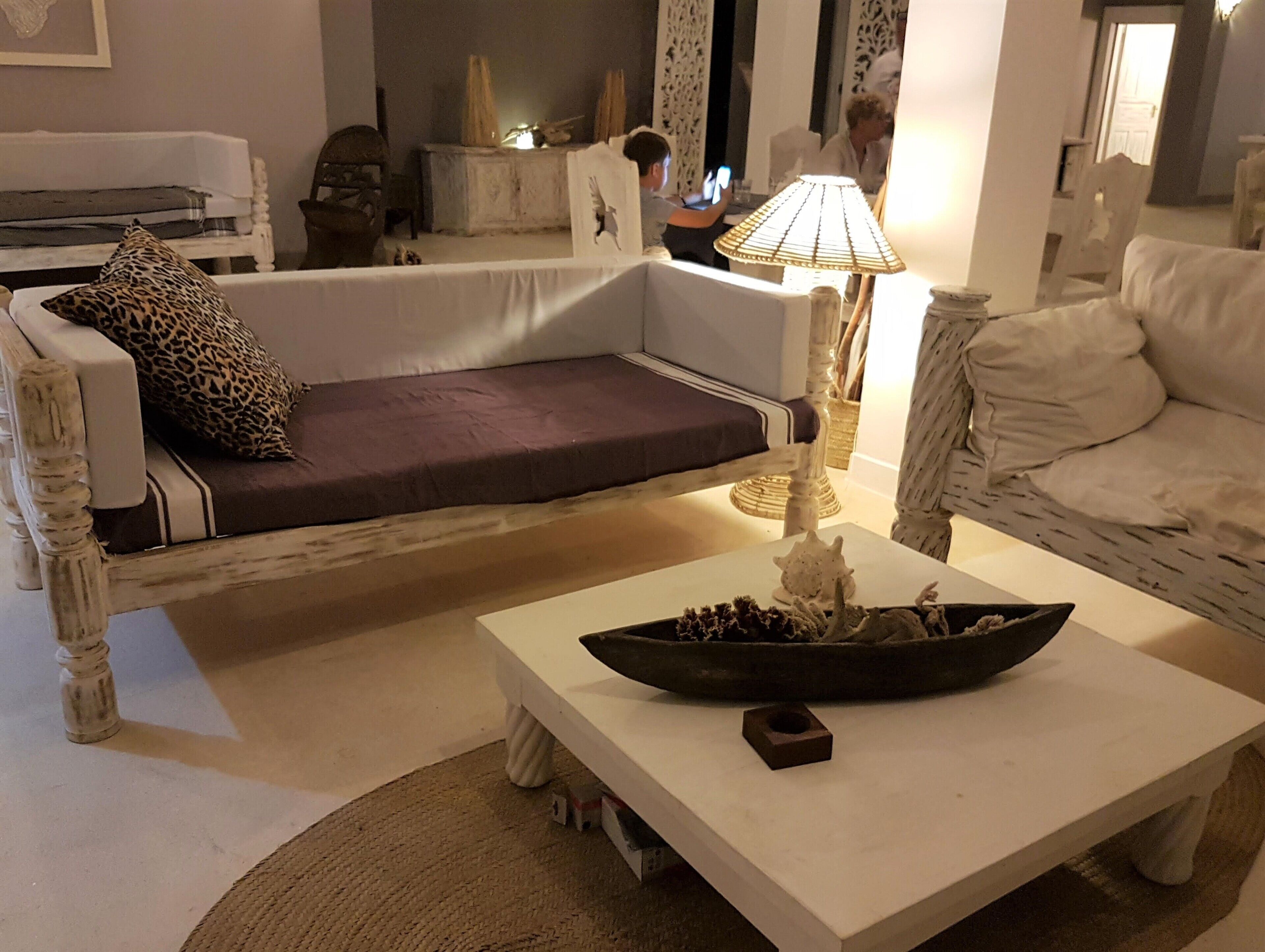 Un salón con un sofá, una mesa de centro con un cuenco decorativo y una lámpara.