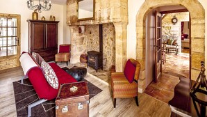 A traditional room with a stone fireplace, wooden furniture, and a large mirror. - MULBERRY TREE Villa - Luxury Villa - Heated Pool, Hot tub, Gym, Garden, Calm (Carmensac, Meyrals)