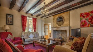A traditional living room with exposed wooden beams, a fireplace, and a television. - MULBERRY TREE Villa - Luxury Villa - Heated Pool, Hot tub, Gym, Garden, Calm (Carmensac, Meyrals)