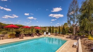 A swimming pool with red umbrellas, lounge chairs, and a view of the surrounding landscape. - MULBERRY TREE Villa - Luxury Villa - Heated Pool, Hot tub, Gym, Garden, Calm (Carmensac, Meyrals)