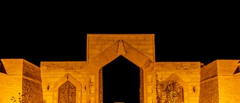 A stone archway leading to a courtyard with a small table in the center.