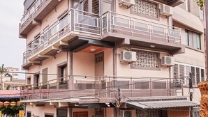 A multi-story building with balconies, air conditioning units, and a small shop at the ground level. - Inn-itiate Tainan (Tainan)