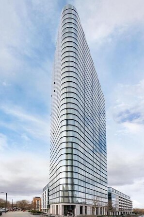 A modern high-rise building with a curved facade, likely a hotel or office building. - Premium One bedroom apartment City Road Basin (London)