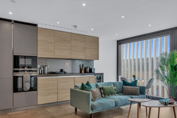Un espacio habitable moderno con cocina, sofá y zona de comedor.