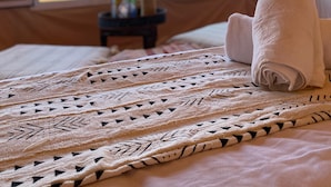 Una carpa con cama, ventana y vistas al desierto.