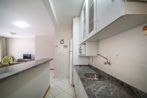A modern kitchen with white cabinets, a granite countertop, and a built-in sink.
