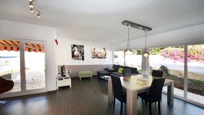 A modern living room with a dining area, large windows, and a view of the outdoors. - Taoro House, Puerto de la Cruz (Puerto de la Cruz)