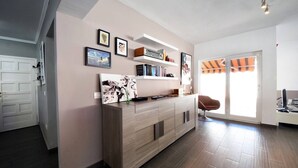 A modern living room with a wooden cabinet, a chair, and a door. - Taoro House, Puerto de la Cruz (Puerto de la Cruz)