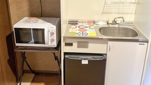 A compact kitchenette with a microwave, sink, and dishwasher. - Comfort Stay Miyabi (Chichibu)