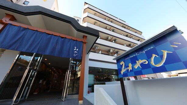 A hotel entrance with a blue awning and a sign reading "Kitagawa". - Comfort Stay Miyabi (Chichibu)