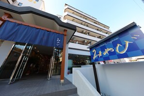 Entrada de un hotel con toldo azul y un letrero que dice "Kitagawa".