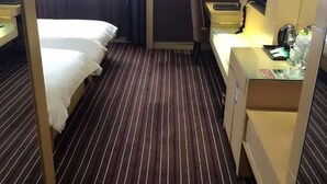 Une chambre d’hôtel avec deux lits, un bureau avec une lampe et un mini-bar.