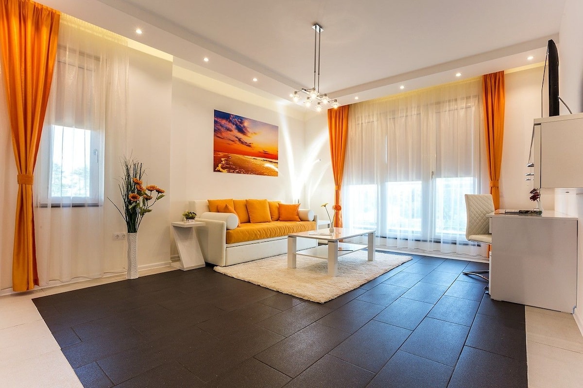 A modern living room with a sofa, coffee table, and a TV stand.