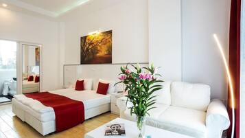 Ein modernes Hotelzimmer mit Bett, Sofa, Couchtisch und einem Gemälde an der Wand.