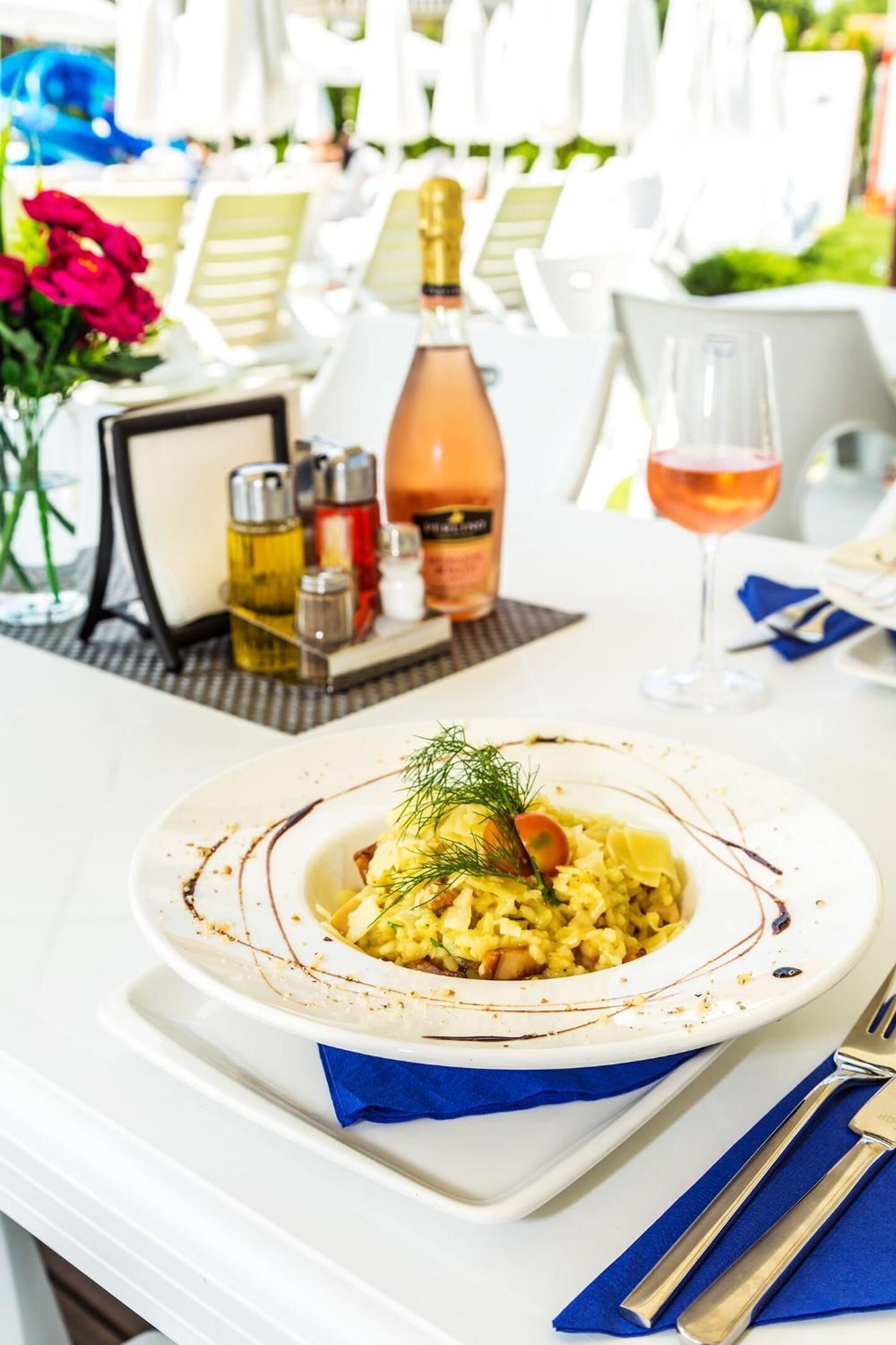 A table with a plate of food, a bottle of wine, and a glass of wine.