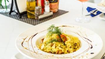 Una mesa con un plato de comida, una botella de vino y una copa de vino.