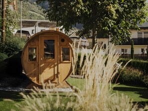 A wooden cabin with a door and windows, surrounded by greenery and a fence. - Historic Charm Meets Modern Comfort: Sauna, Mountain Views & Terrace. Pets Welcome! (PARTSCHINS)