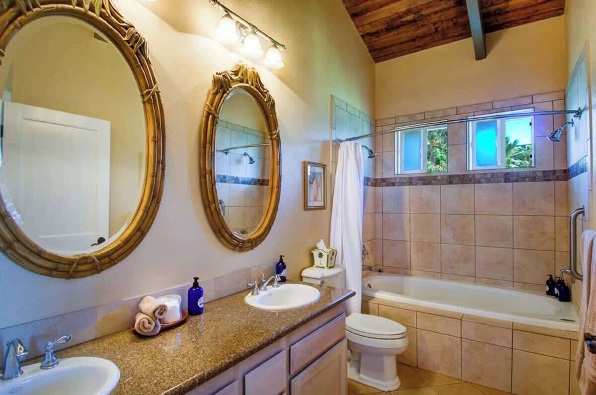 Ein Badezimmer mit zwei Waschbecken, einer Toilette und einer Badewanne.