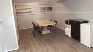 A compact kitchen with a dining table, chairs, a microwave, and a refrigerator. - Suite With Private Entrance 20 min to YYC Airport (Airdrie, Canada)