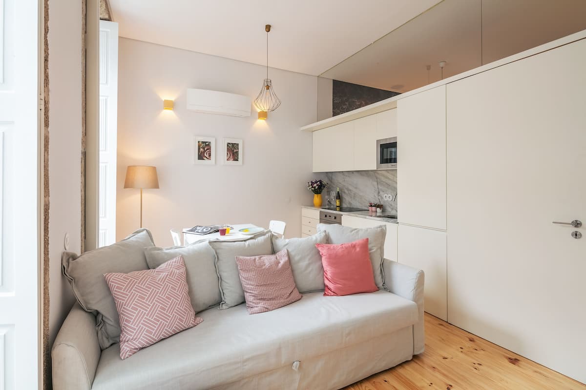 Een moderne woonkamer met een bank, een eettafel en een keukenhoek.