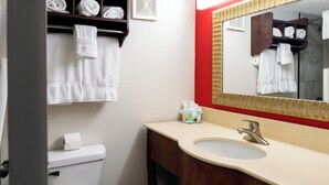 A bathroom with a toilet, sink, and towel rack. - American Inn and Suites Ferndale (Ferndale)