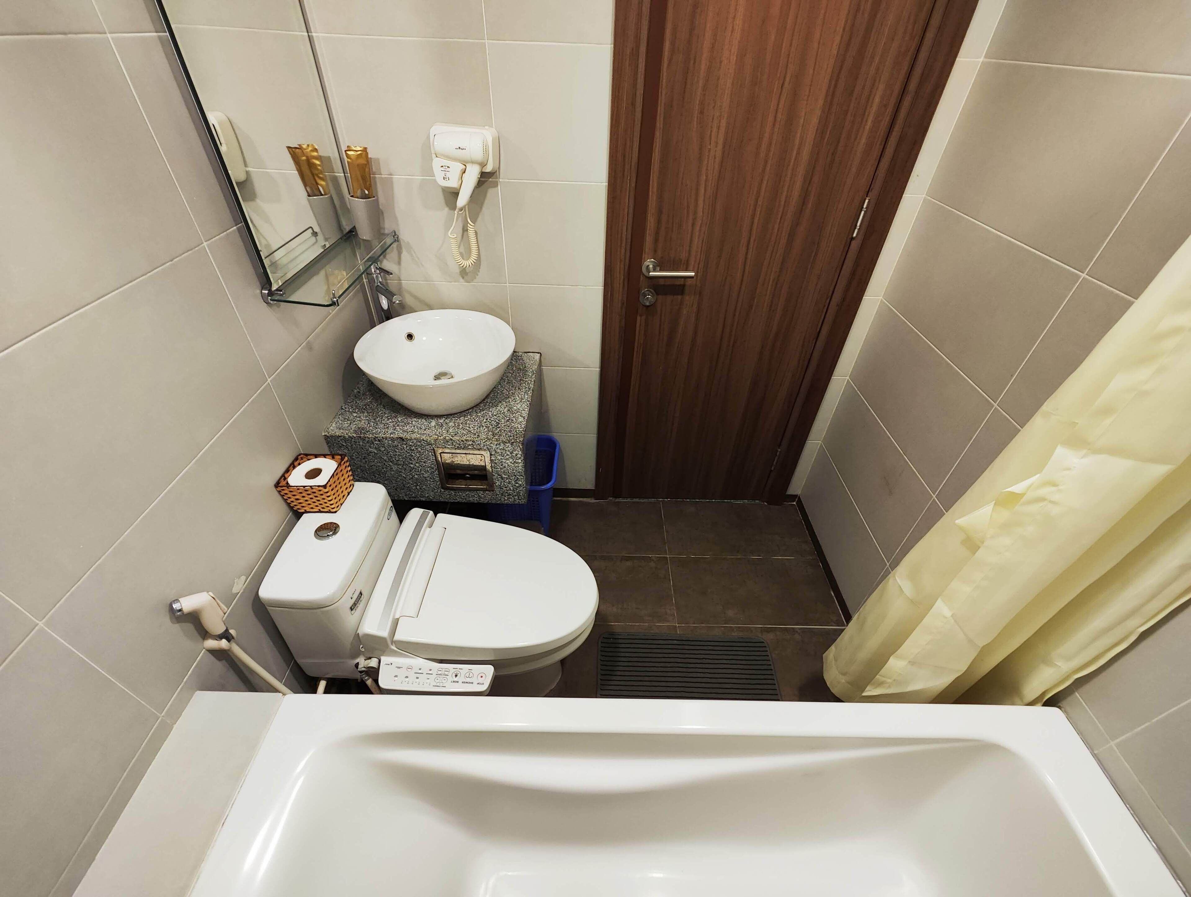Une petite salle de bain comprenant des toilettes, un lavabo et une douche.