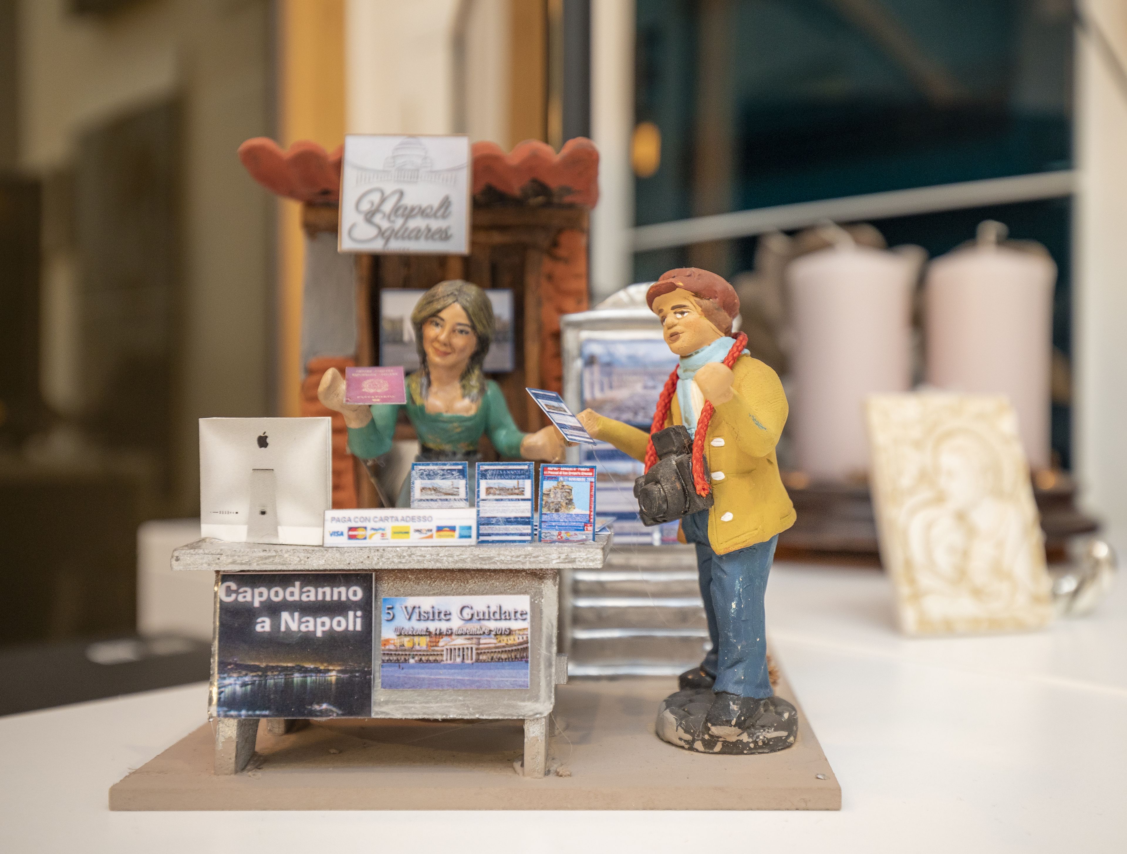 A miniature model of a tourist information booth with a sign reading "Capodanno a Napoli" and "5 Visite Guidate".