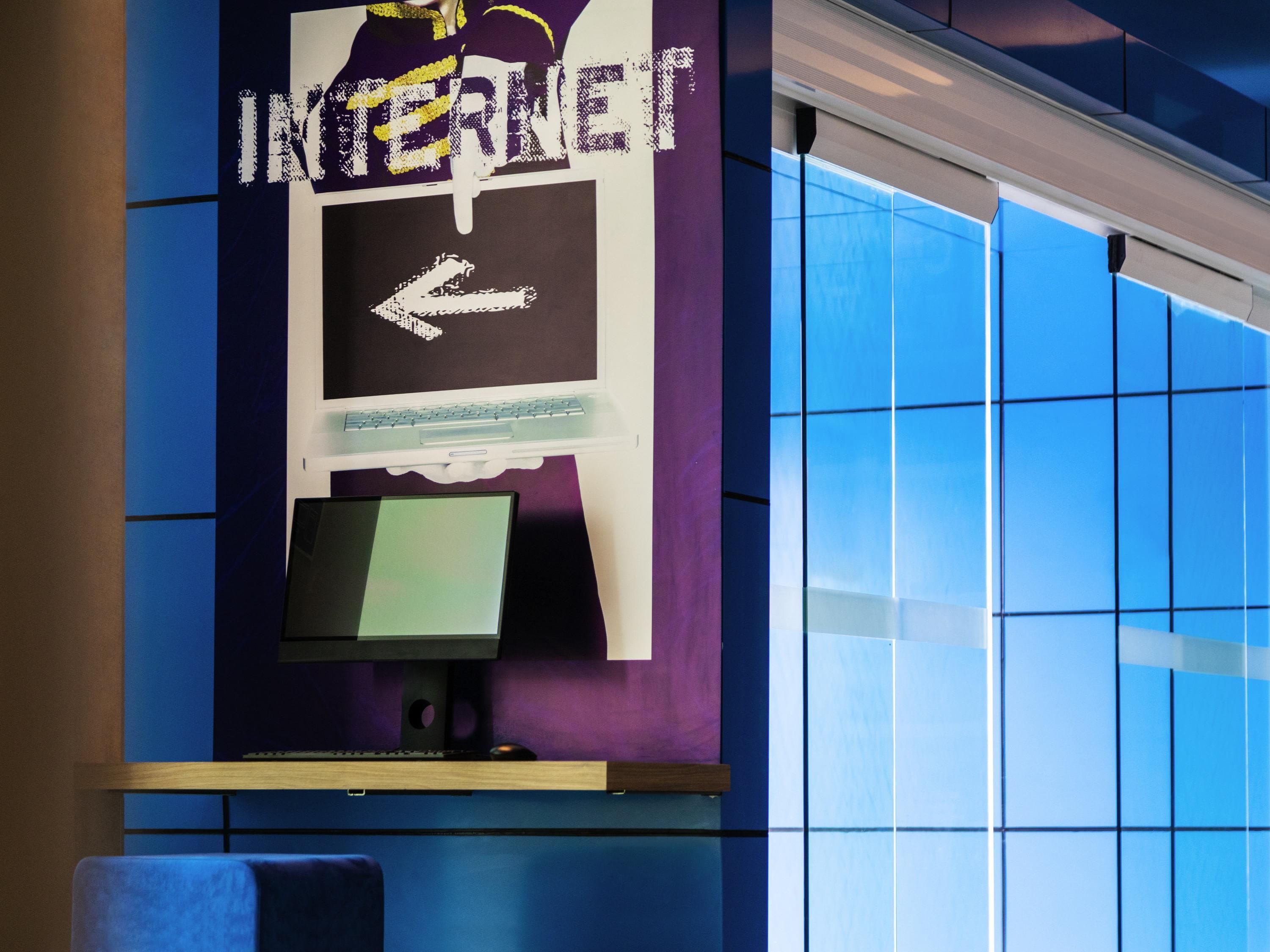 Un écran d’ordinateur, un clavier et un panneau indiquant le mot « INTERNET » avec une flèche pointant vers la gauche.