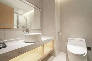 Ein modernes Badezimmer mit Waschbecken, Spiegel und Toilette in Weiß.