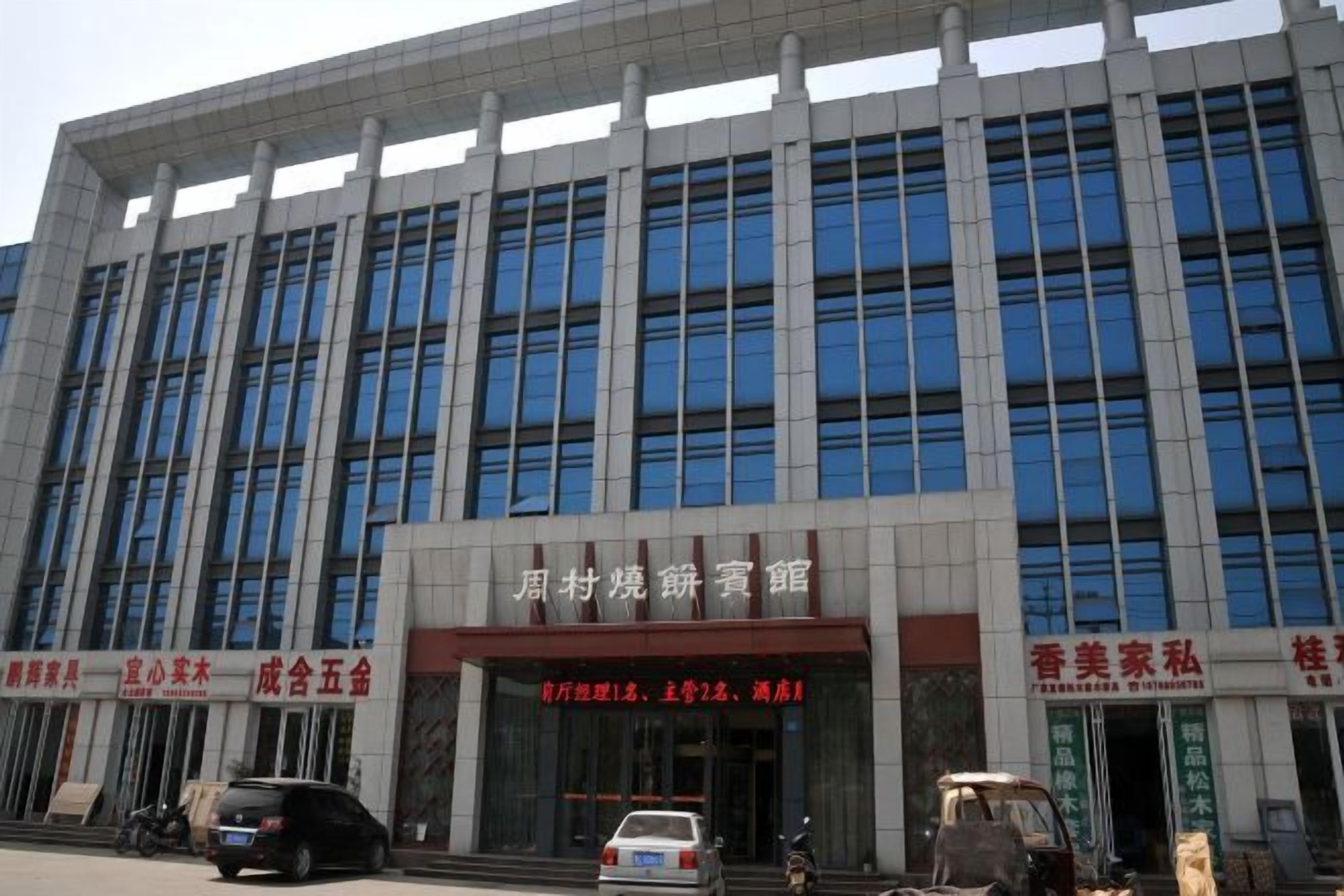 A multi-story building with a large entrance and several signs.
