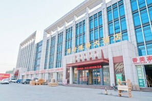 A large building with multiple storefronts, including a prominent red awning with Chinese characters. - Zhoucun Shaobing Hotel (Zibo)