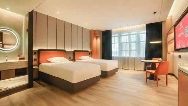 A hotel room with two beds, a desk, a chair, a mirror, and a TV. - Zhoucun Shaobing Hotel (Zibo)