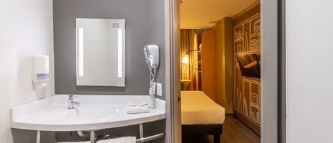 A modern bathroom with dual sinks, a mirror, and a hairdryer.