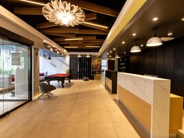 Un espacio interior moderno con una mesa de billar, una recepción y una zona de estar con asientos.