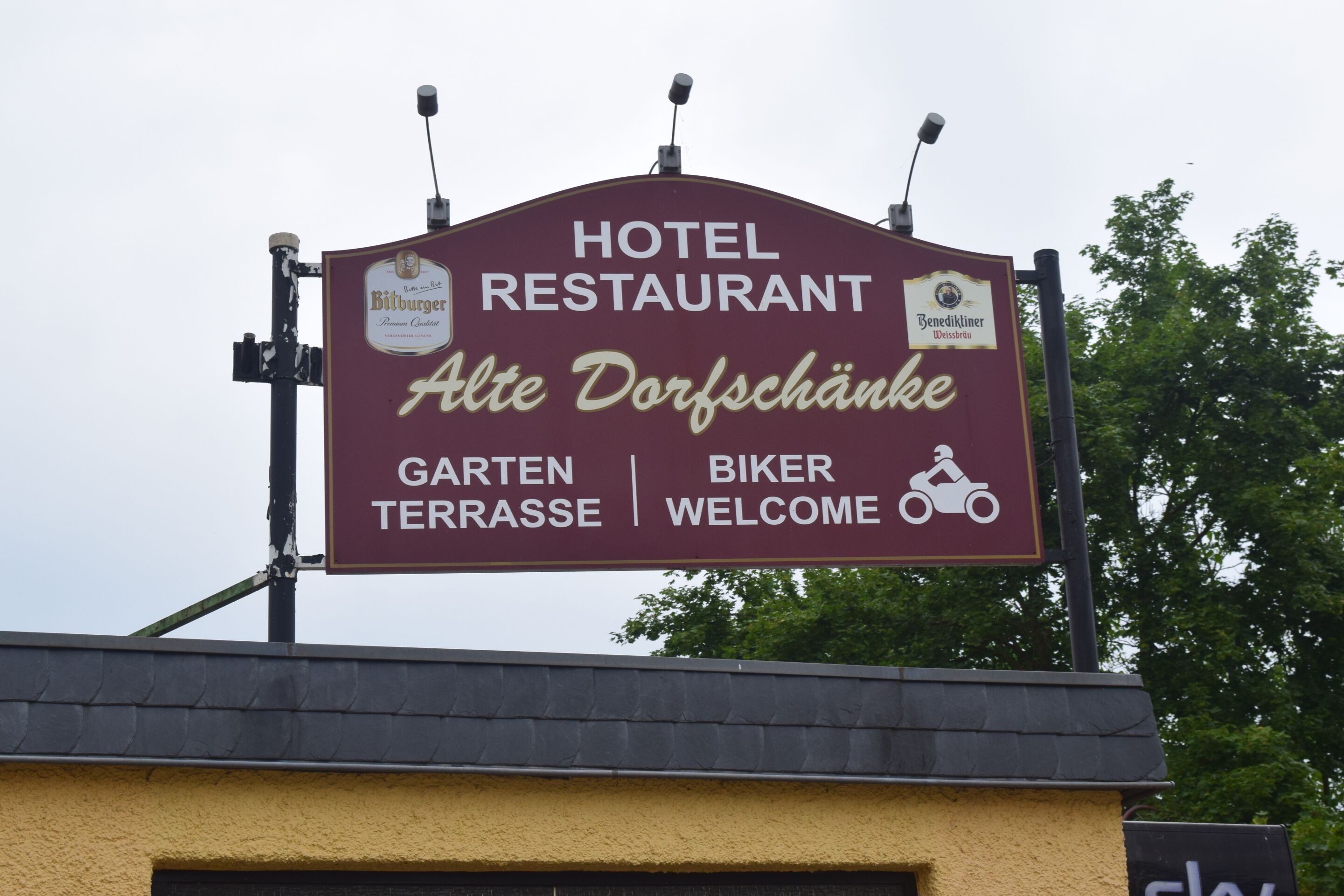 A hotel restaurant sign with "HOTEL RESTAURANT" and "Alte Dorfschänke" text.
