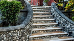 A multi-story building with a stone staircase leading to a balcony. - Hacienda Barrigona (Sámara)