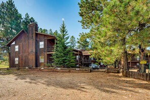 A rustic lodge with a large wooden structure, a covered deck, and a gravel driveway. - Cozy Angel Fire Condo < Half Mi to Resort! (Angel Fire)