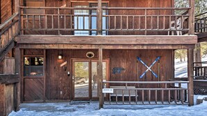 Un bâtiment en bois doté d’un escalier à double révolution, d’une porte en bois et d’un banc.