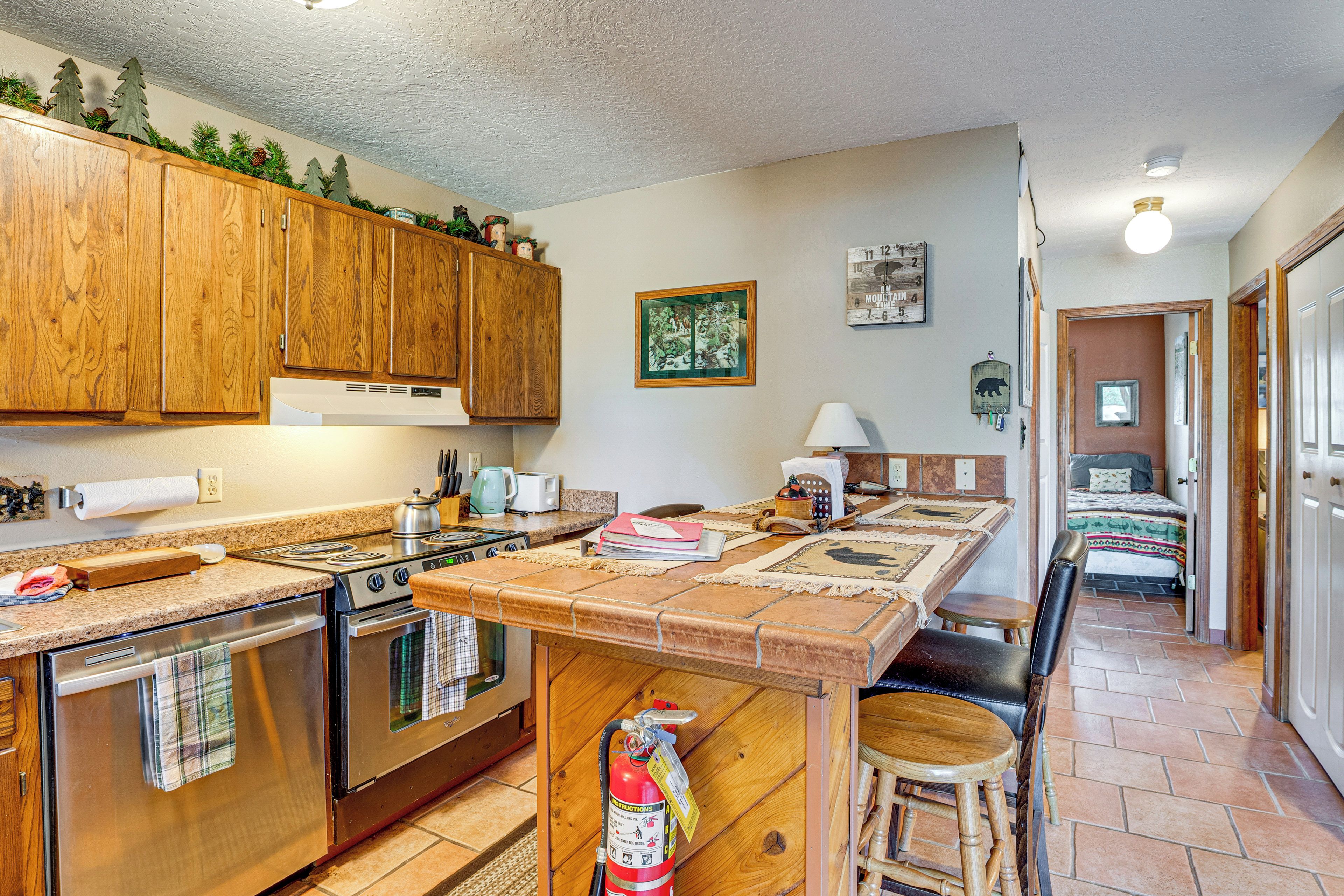 A kitchen with wooden cabinets, a stove, and a countertop with various items.