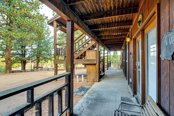 A covered wooden walkway with a metal railing, leading to a building with a 'Welcome' sign. - Cozy Angel Fire Condo < Half Mi to Resort! (Angel Fire)